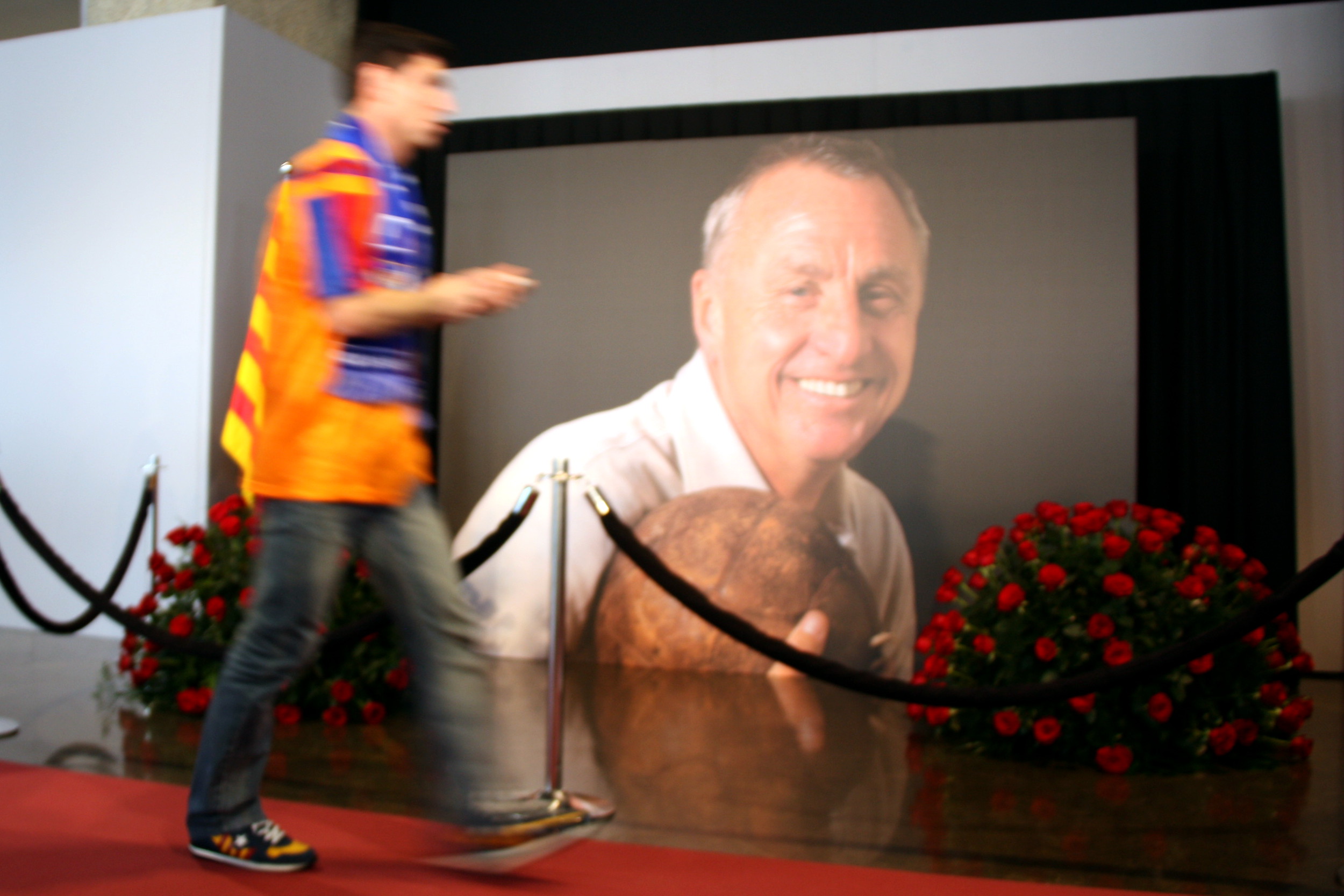Un seguidor barcelonista passa per davant de la fotografia de Johan Cruyff que presideix el memorial al Camp Nou, el 26 de març de 2016 / ACN