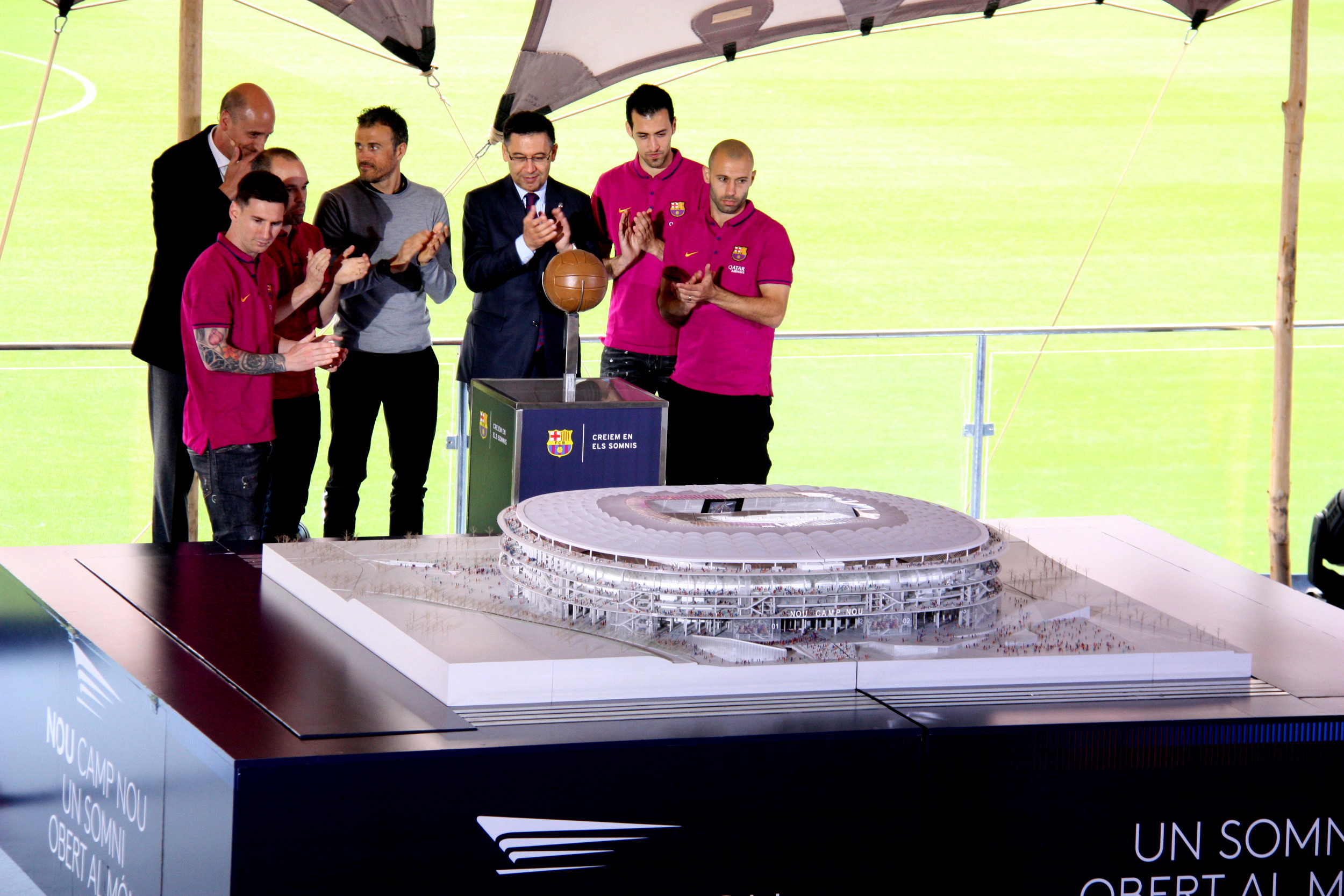 Leo Messi, Andrés Iniesta, Jordi Moix, Luis Enrique Martínez, Josep Maria Bartomeu, Sergio Busquets i Javier Mascherano observant com es descobreix la maqueta del nou Camp Nou, el 21 d'abril del 2016 / ACN