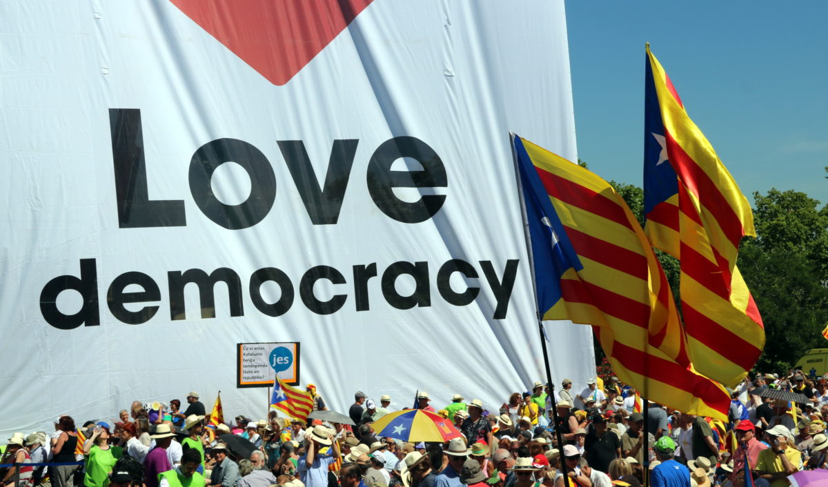 Imatge d'un plafó que ha presidit l'acte en favor del referèndum on es llegeix en anglès 'Estimem la democràcia' / Àlex Recolons