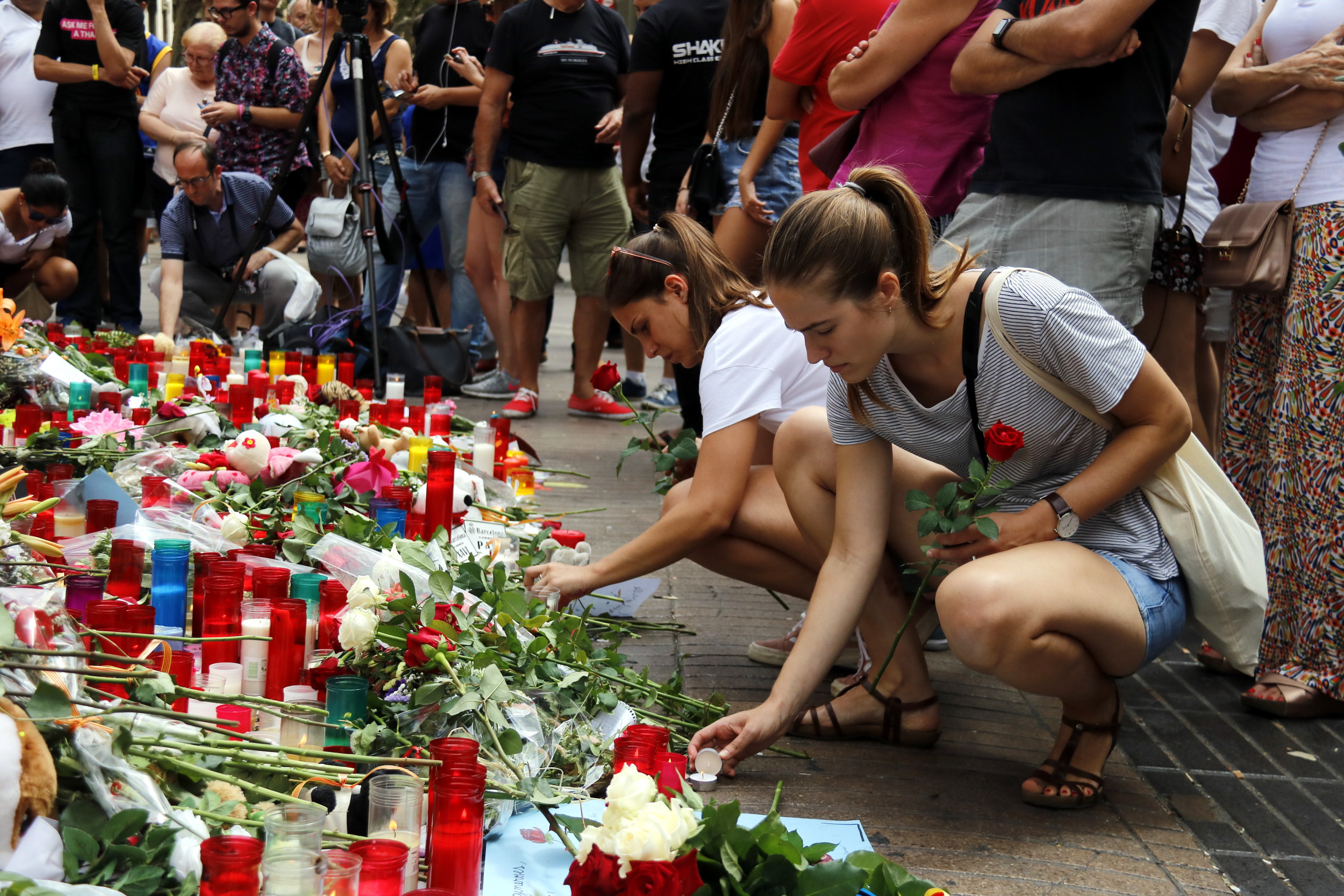 Dues noies encenen espelmes a les Rambles, en un dels punts improvisats de record a les víctimes dels atemptats / Jordi Pujolar