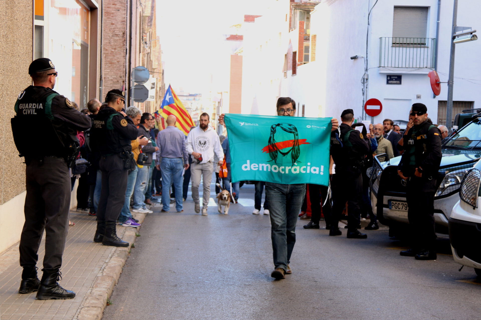 Un home amb la pancarta 'democràcia' d'Òmnium Cultural durant el registre de la Guàrdia Civil a l'empresa Unipost de Terrassa / Norma Vidal