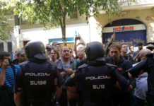 La policia espanyola envoltant la seu de la CUP, mentre simpatitzants criden en contra de l'actuació i en favor de l'1-O / CUP